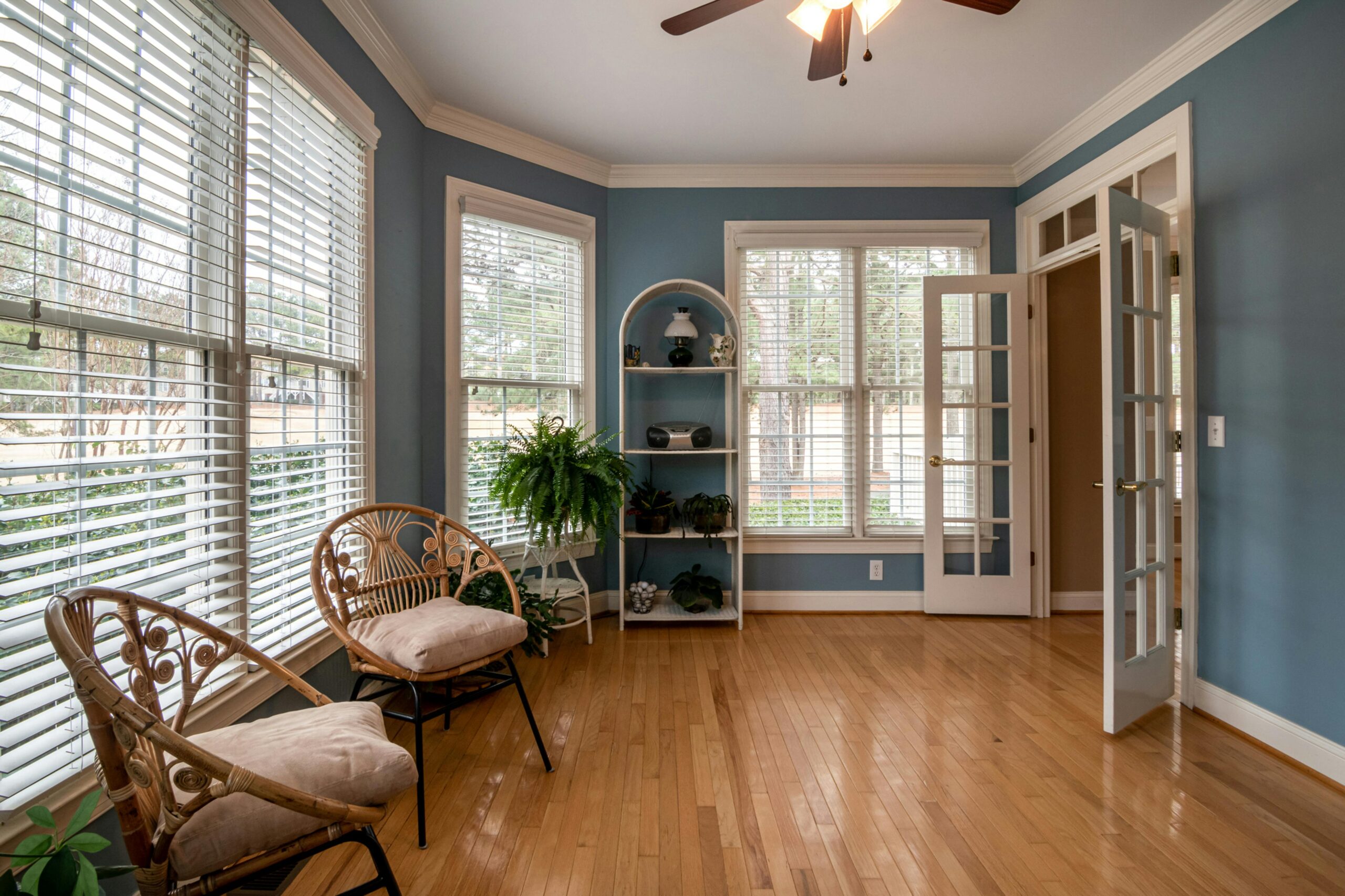 A sitting room with open white venetian blinds, representing how to  choose the perfect blinds for every room in your home